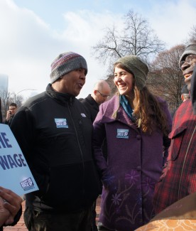 Two JOIN alums looking at each other, smiling, at outdoor rally