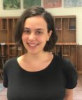 Emma Rose Borzekowski headshot, in front of shelves. 