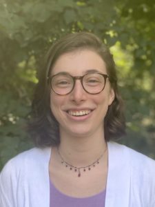 headshot of Abby Bresler with foliage in the background