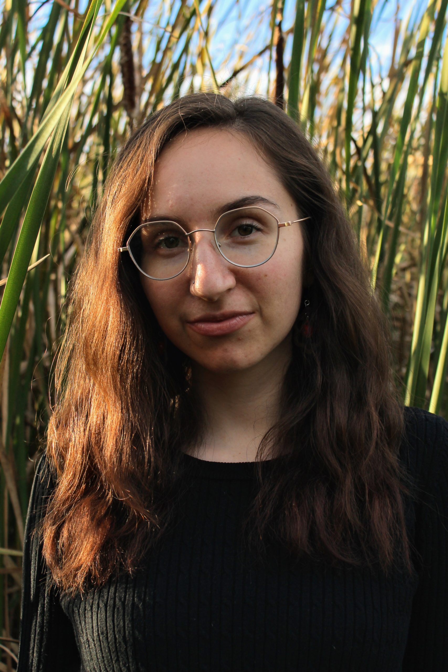 headshot of Emunah Woolf standing in front of tall grasses