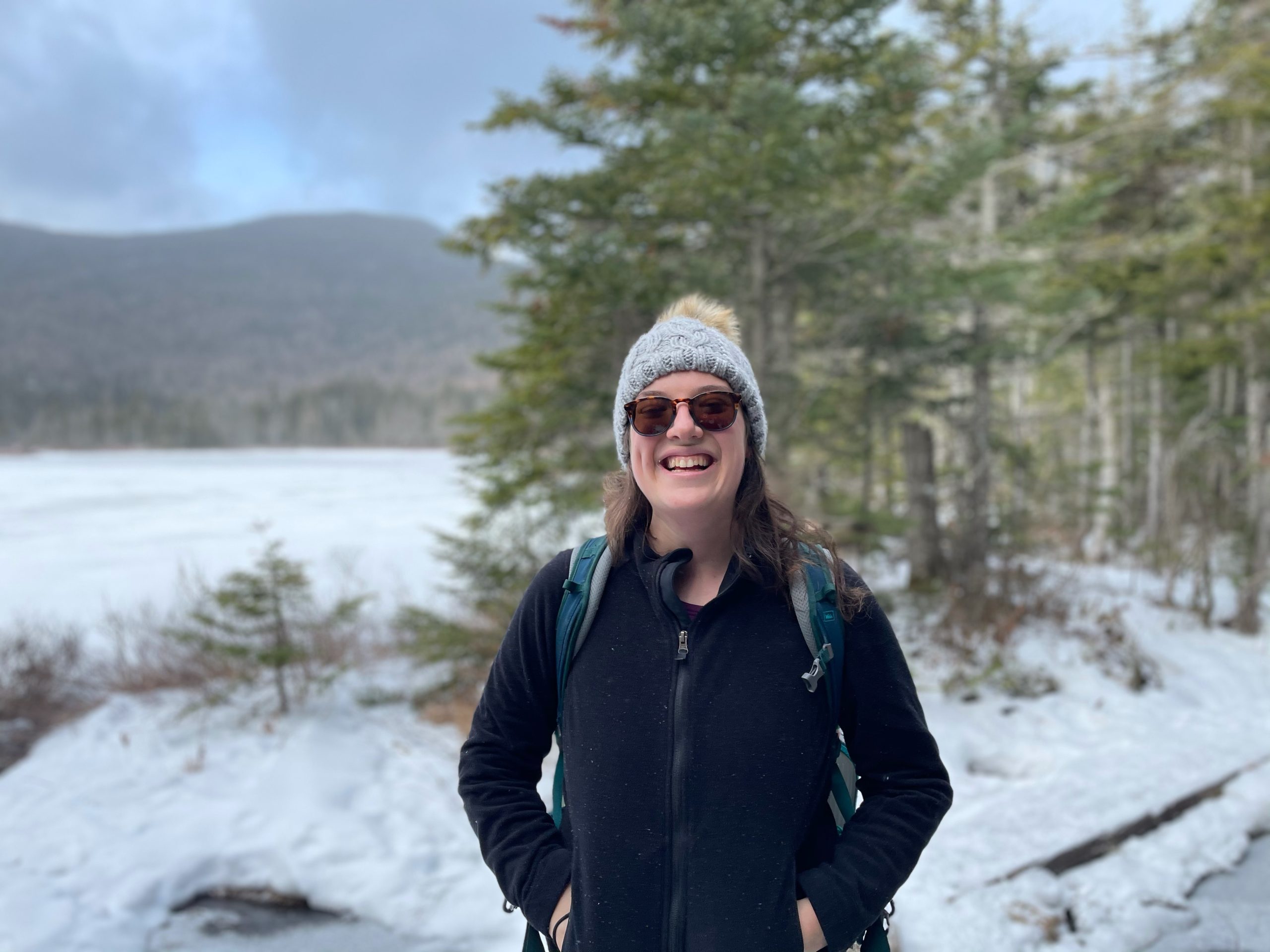 photo of Eviva Kahne standing outside where snow, trees, and a distant mountain can be seen