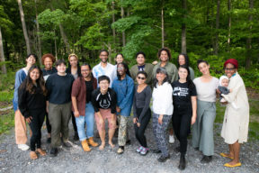 Group photo taken outdoors against a forest background of the Jews of Color 2023-2024 Fellowship Cohort.